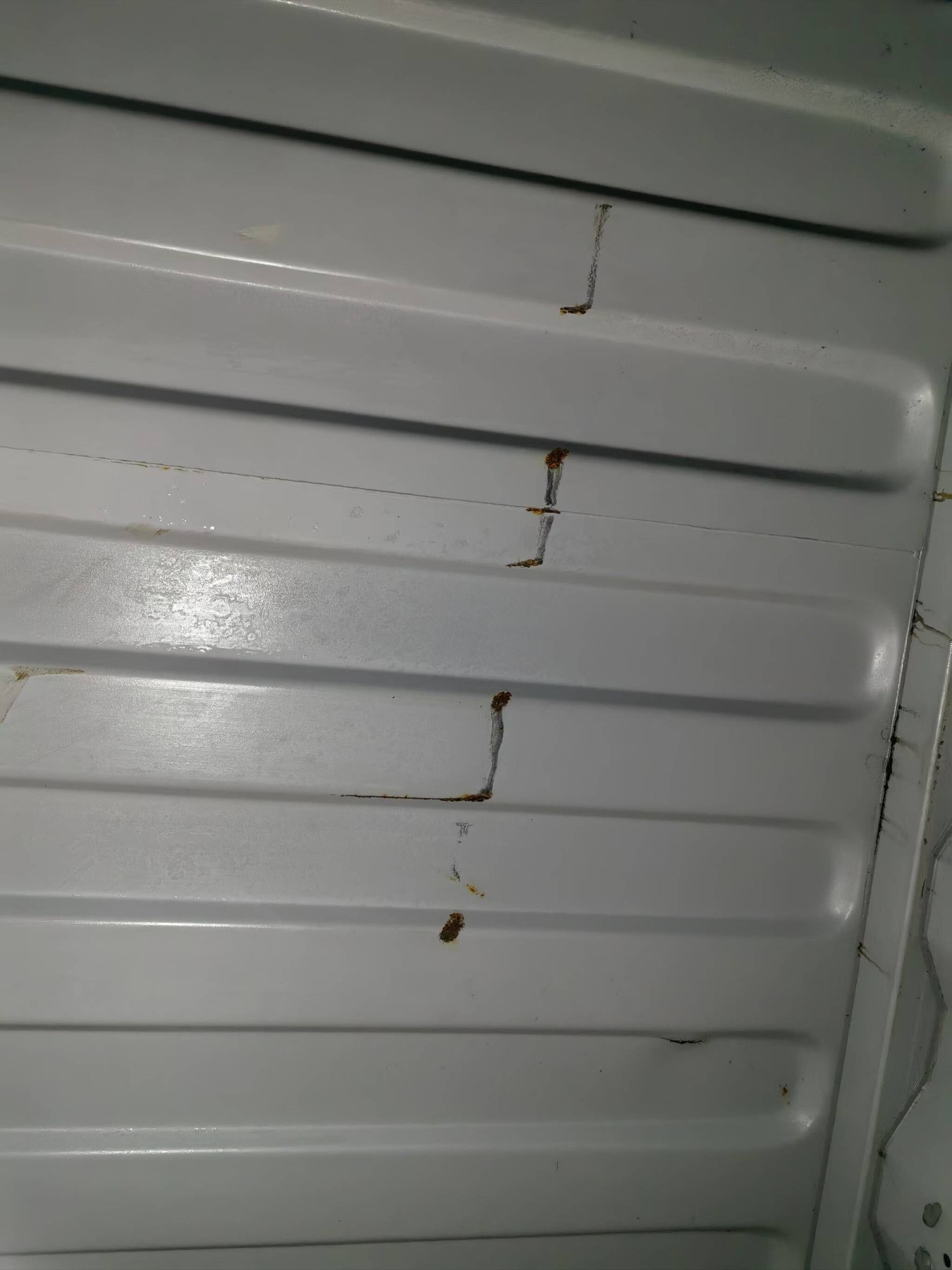Rust marks across the container's interior roof panels