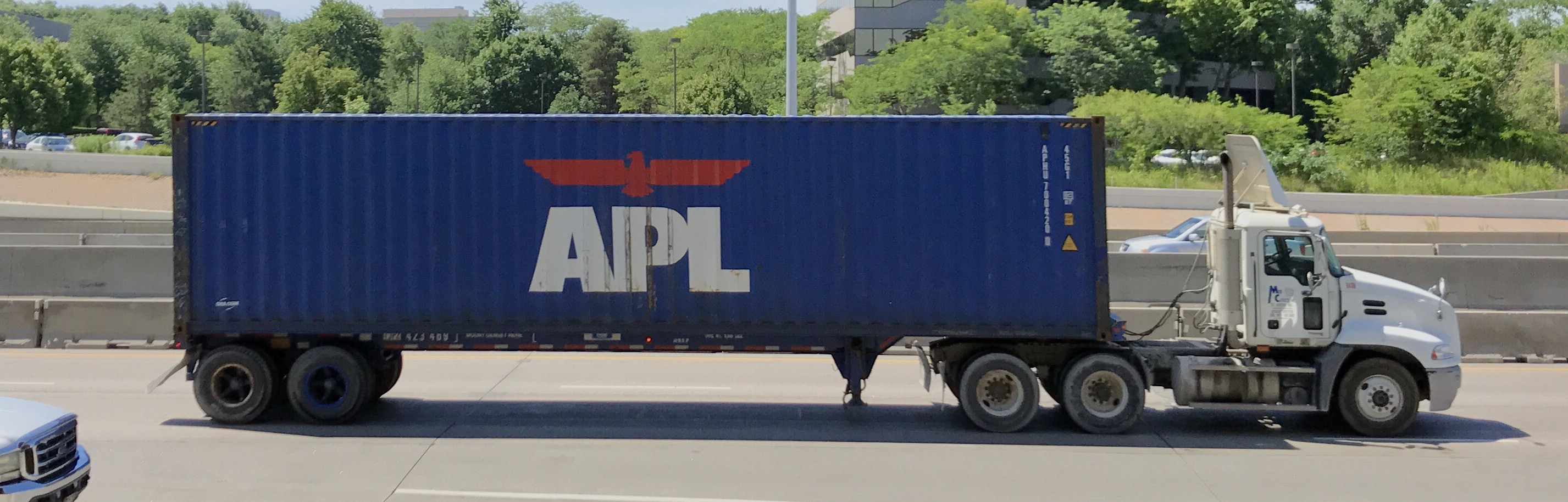 A shipping container carried on a chassis behind a tractor